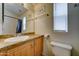 Bathroom featuring a single sink vanity, ample lighting, and a toilet in a neutral color scheme at 111 S Greenfield Rd # 244, Mesa, AZ 85206