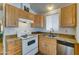 Functional kitchen with light wood cabinets, granite counters, and stainless-steel dishwasher at 111 S Greenfield Rd # 244, Mesa, AZ 85206