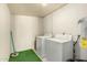Laundry room with a washer, dryer, and water heater with white brick walls and a green mat at 126 N 58Th St, Mesa, AZ 85205