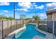 Swimming pool surrounded by a black safety fence in a backyard with green grass and blue skies at 1307 E Broadmor Dr, Tempe, AZ 85282