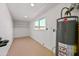 Utility room with hot water tank, small window and blank shelves at 1307 E Broadmor Dr, Tempe, AZ 85282
