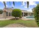 Beautiful backyard featuring a pool, covered patio, well-manicured lawn, and mature landscaping at 15501 W Camino Real Way, Surprise, AZ 85374