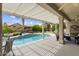 Relaxing backyard pool area with shaded patio, comfortable seating, and lush landscaping at 15501 W Camino Real Way, Surprise, AZ 85374
