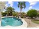 Landscaped backyard featuring a refreshing pool, mature palm trees, and well-maintained greenery at 15501 W Camino Real Way, Surprise, AZ 85374