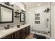 This remodeled bathroom includes dual sinks, dark wood cabinets, and a glass walk-in shower at 15501 W Camino Real Way, Surprise, AZ 85374