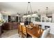 Open concept dining area with modern lighting, wood floors, and seamless flow to the living room and kitchen at 15501 W Camino Real Way, Surprise, AZ 85374