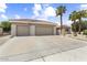Spacious three-car garage and driveway, with a well-maintained exterior and desert-friendly landscaping at 15501 W Camino Real Way, Surprise, AZ 85374