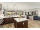 Large kitchen with island and bar top, showcasing stainless steel appliances, connecting living and dining spaces at 15501 W Camino Real Way, Surprise, AZ 85374
