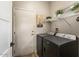 Functional laundry room featuring modern washer and dryer, overhead storage, and a utility door at 15501 W Camino Real Way, Surprise, AZ 85374