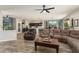 Open-concept living area with hardwood floors connecting the kitchen, dining, and seating spaces at 15501 W Camino Real Way, Surprise, AZ 85374