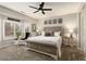 Cozy main bedroom featuring a plush bed, side tables, ceiling fan and large windows with shutters at 15501 W Camino Real Way, Surprise, AZ 85374