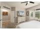 This main bedroom features a ceiling fan, large window, and a beach scene on the TV at 15501 W Camino Real Way, Surprise, AZ 85374