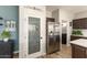Close-up of stainless steel refrigerator and pantry door with decorative glass and shelving at 15501 W Camino Real Way, Surprise, AZ 85374