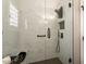 This stylish walk-in shower features floor-to-ceiling marble tile and black fixtures at 15501 W Camino Real Way, Surprise, AZ 85374
