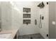 This stylish walk-in shower is tiled with decorative insets, a rainfall shower head and a bench at 15501 W Camino Real Way, Surprise, AZ 85374