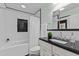 Well-lit bathroom with white tile, dark accents, bathtub, and vanity at 15614 N Lakeforest Dr, Sun City, AZ 85351