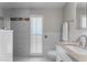 Bright bathroom featuring marble tile, a window with shutters, and a sink with a tan countertop at 15614 N Lakeforest Dr, Sun City, AZ 85351