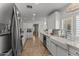 Contemporary kitchen with stainless steel appliances, a farmhouse sink, and bright white cabinetry at 15614 N Lakeforest Dr, Sun City, AZ 85351