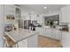 Spacious kitchen featuring an island with seating, white cabinets, and modern appliances for a gourmet experience at 15614 N Lakeforest Dr, Sun City, AZ 85351