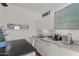 Modern kitchenette with white cabinets, stainless appliances, and adjacent dining area at 15614 N Lakeforest Dr, Sun City, AZ 85351