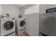 Functional laundry room featuring a washer, dryer, and shelving for storage, with stylish decor at 15614 N Lakeforest Dr, Sun City, AZ 85351