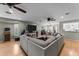 Open-concept living room with wood floors, sectional sofa, and seamless flow to other living spaces at 15614 N Lakeforest Dr, Sun City, AZ 85351