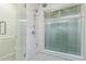Modern bathroom shower with white tile, glass doors, and nice fixtures at 15849 N 46Th Pl, Phoenix, AZ 85032
