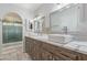Bright bathroom featuring double sinks with white countertops and wood-look cabinets at 15849 N 46Th Pl, Phoenix, AZ 85032