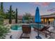 Sparkling pool area with inviting lounge chairs and a shade umbrella, perfect for backyard relaxation at 15849 N 46Th Pl, Phoenix, AZ 85032