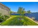 Backyard with artificial grass, landscaping, and surrounding privacy wall, ideal for outdoor activities at 16396 W Fillmore St, Goodyear, AZ 85338