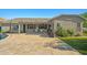 Paver patio with ceiling fans, grill, and seating areas with an expansive view of the grassy backyard at 16396 W Fillmore St, Goodyear, AZ 85338
