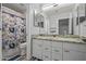 Bathroom featuring double sinks with granite countertops and a shower at 16396 W Fillmore St, Goodyear, AZ 85338