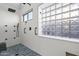 Updated bathroom has white tiled walls, an accent glass block window, and a rainfall shower head at 16396 W Fillmore St, Goodyear, AZ 85338