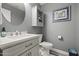 Charming half bath features a round mirror, cabinet, and stylish fixtures at 16396 W Fillmore St, Goodyear, AZ 85338