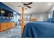Spacious bedroom features a four-poster bed, blue accent wall with TV, and stylish blue area rug at 16396 W Fillmore St, Goodyear, AZ 85338