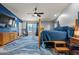 Bright bedroom boasts a four-poster bed, blue accents, and a decorative area rug on a hardwood floor at 16396 W Fillmore St, Goodyear, AZ 85338