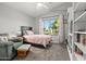 Sunlit bedroom featuring a cozy chair and large window with neighborhood views at 16396 W Fillmore St, Goodyear, AZ 85338