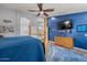 Stylish bedroom has a four-poster bed, blue accents, and an ensuite bathroom with modern fixtures at 16396 W Fillmore St, Goodyear, AZ 85338