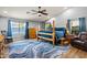 Well-lit bedroom showcases a four-poster bed, hardwood floors with a patterned area rug and neutral walls at 16396 W Fillmore St, Goodyear, AZ 85338