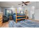 Nicely appointed bedroom shows a four-poster bed, a comfortable chair, and wood flooring with area rug at 16396 W Fillmore St, Goodyear, AZ 85338