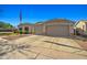 Suburban home with a large driveway, a two-car garage and a flag pole on a sunny day at 16396 W Fillmore St, Goodyear, AZ 85338