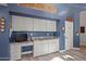 Bright kitchen featuring ample white cabinets, granite counters, and a cozy built in desk area at 16396 W Fillmore St, Goodyear, AZ 85338