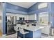 Bright kitchen featuring white cabinetry, stainless steel appliances, and a central island with bar seating at 16396 W Fillmore St, Goodyear, AZ 85338