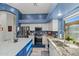 Modern kitchen with stainless steel appliances, granite counters, a center island, and white cabinets at 16396 W Fillmore St, Goodyear, AZ 85338