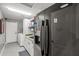 Functional laundry room featuring a modern washer and dryer set, gray cabinets, and a black refrigerator at 16396 W Fillmore St, Goodyear, AZ 85338