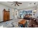 Open living room with an ornate rug, a leather sofa, a ceiling fan, and hardwood floors at 16396 W Fillmore St, Goodyear, AZ 85338