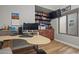 Home office with wood built-ins, a modern desk, wood floors, and a decorative window at 16396 W Fillmore St, Goodyear, AZ 85338