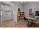 Home office featuring hardwood floors, a gray accent wall, and an open doorway to a bathroom at 16396 W Fillmore St, Goodyear, AZ 85338