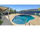 A backyard pool with baja step entry surrounded by patio with outdoor seating and landscaping at 16396 W Fillmore St, Goodyear, AZ 85338