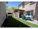 Inviting backyard features a covered patio and a manicured artificial grass area, perfect for outdoor relaxation and entertaining at 16425 W Latham St, Goodyear, AZ 85338
